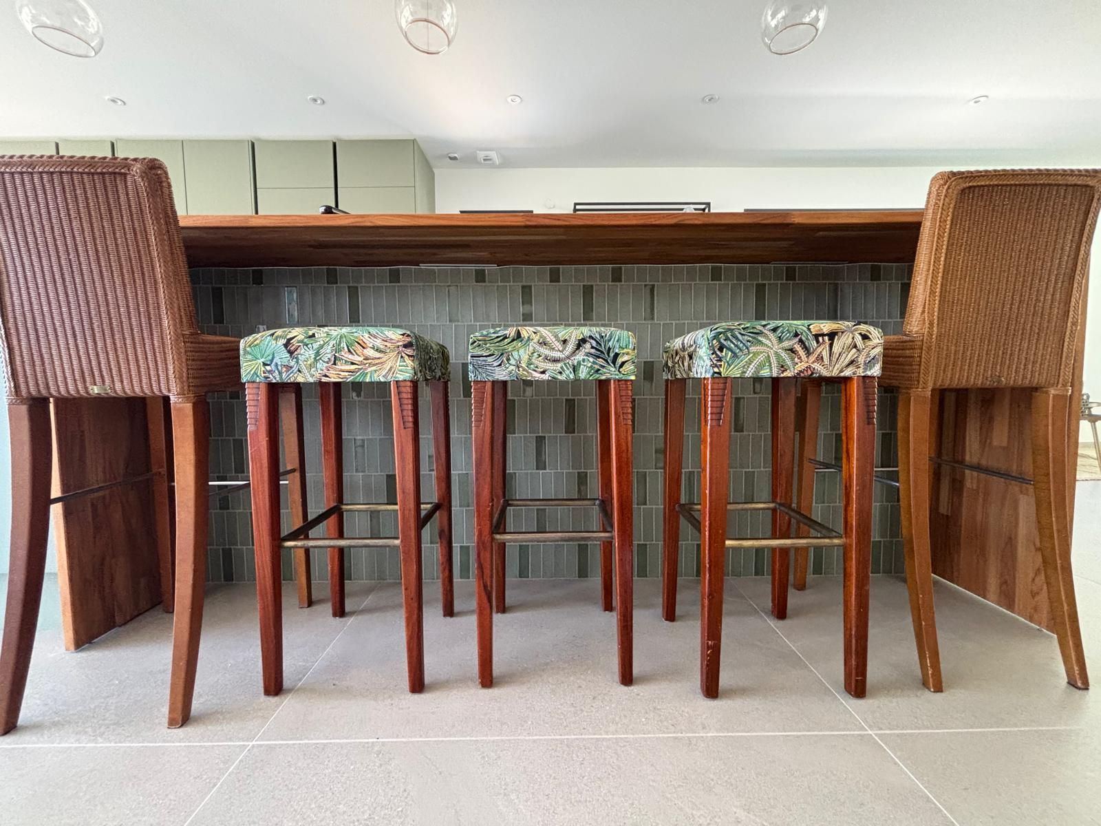 Comptoir en bois et tabourets au tissu végétal dans la cuisine du cabinet